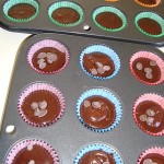 Uncooked brownie cakes ready for the oven (12 are sprinkled with dk choc drops)